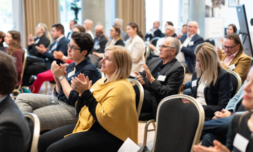 Applaus im Publikum beim Treffpunkt Gesundheitsindustrie 2025 Mehrere Personen sitzen in einem Veranstaltungsraum und applaudieren während einer Konferenz.