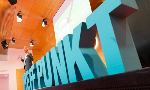  Das Wort Treffpunkt in blauen Großbuchstaben aus Schaumstoff steht auf der Bühne.