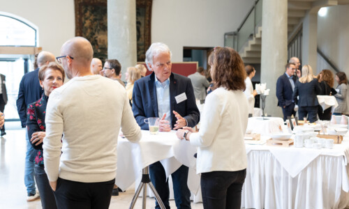 Gespräche bei der Kaffeepause auf dem Treffpunkt Gesundheitsindustrie 2025 Mehrere Personen stehen an Stehtischen in einem hellen Veranstaltungsraum und unterhalten sich während einer Kaffeepause. Im Hintergrund sind Tische mit Geschirr und Snacks zu sehen.