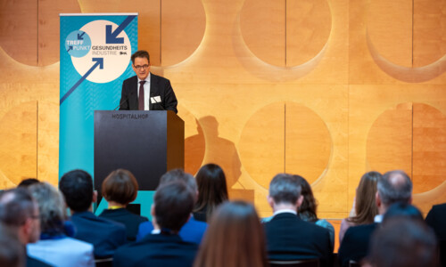 Ein Herr im Anzug spricht von der Bühne.